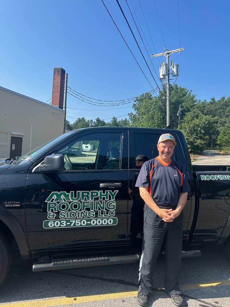 Man smiling and standing in front of Murphy Roofing pickup truck